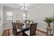 Traditional dining room featuring hardwood floors, a decorative rug, and a modern chandelier at 2912 Historic Cir, Morrisville, NC 27560