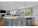Open kitchen with quartz countertops and stainless appliances overlooks living area at 2912 Historic Cir, Morrisville, NC 27560