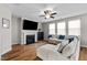 Bright living room with fireplace, large TV, ceiling fan, and comfortable sectional sofa at 2912 Historic Cir, Morrisville, NC 27560