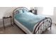Bedroom featuring a metal bed frame, a blue quilt, and neutral-toned carpet at 3005 Dunnock Dr, Durham, NC 27713