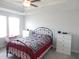 Bright bedroom featuring a metal-frame bed with a patterned quilt and dual dressers at 3005 Dunnock Dr, Durham, NC 27713