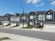 Street view of modern townhomes with dark siding and a red truck parked in the driveway at 3005 Dunnock Dr, Durham, NC 27713