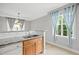 Bright kitchen with granite countertops, double sink, wooden cabinets, and natural light from the window at 324 Providence Glen Dr, Chapel Hill, NC 27514