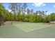 Well-maintained community tennis court with green surface, lighting, and surrounding trees at 324 Providence Glen Dr, Chapel Hill, NC 27514