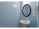 Powder room featuring a pedestal sink, decorative mirror and light blue walls at 3411 Massey Pond Trl, Raleigh, NC 27616