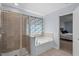 Bathroom showcases a glass-enclosed shower, soaking tub with floral curtain, and access to bedroom at 3411 Massey Pond Trl, Raleigh, NC 27616