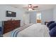 Main bedroom with a dresser, flat-screen TV, ceiling fan, and en-suite bathroom at 3411 Massey Pond Trl, Raleigh, NC 27616
