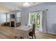 Bright dining area features light blue walls, wood floors, sliding glass doors to backyard, and a fireplace in the next room at 3411 Massey Pond Trl, Raleigh, NC 27616