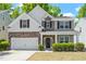 Charming two-story home with stone and siding exterior, two-car garage, and well-manicured landscaping at 3411 Massey Pond Trl, Raleigh, NC 27616