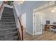 Inviting foyer with staircase, leading to a home office with glass door and wood floors at 3411 Massey Pond Trl, Raleigh, NC 27616