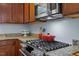 Close-up of kitchen with gas cooktop, granite countertops, and stainless-steel microwave at 3411 Massey Pond Trl, Raleigh, NC 27616