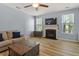 Comfortable living room boasts a decorative fireplace, flat-screen TV, and wood-look flooring at 3411 Massey Pond Trl, Raleigh, NC 27616