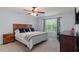 Comfortable main bedroom with a wood-frame bed, ceiling fan, and a large window at 3411 Massey Pond Trl, Raleigh, NC 27616