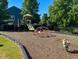 Community playground with slides and climbing areas, surrounded by woodchips at 3411 Massey Pond Trl, Raleigh, NC 27616