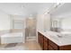 Bathroom features double sinks, a bathtub, and glass enclosed shower with neutral tile at 3513 Diamond Springs Dr, Raleigh, NC 27610