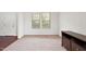 Bright bedroom featuring neutral carpet, two windows, and dark wood trim at 3513 Diamond Springs Dr, Raleigh, NC 27610