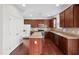 Spacious kitchen featuring dark wood cabinets, stainless steel appliances, and an island with countertop seating at 3513 Diamond Springs Dr, Raleigh, NC 27610
