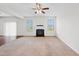 Spacious living room with a fireplace, ceiling fan, carpet floors, and natural light from the windows at 3513 Diamond Springs Dr, Raleigh, NC 27610