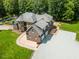 Aerial view of brick home with circular driveway, three-car garage, and landscaped yard at 3704 Hesters Store Rd, Hurdle Mills, NC 27541