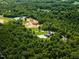 An aerial view shows a private estate surrounded by dense trees, offering seclusion and natural beauty at 3704 Hesters Store Rd, Hurdle Mills, NC 27541