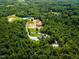 Expansive aerial view captures the home and property in its lush, wooded setting at 3704 Hesters Store Rd, Hurdle Mills, NC 27541