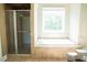 A bathroom featuring a shower and tub in a tiled surround at 3704 Hesters Store Rd, Hurdle Mills, NC 27541