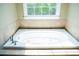 Large white bathtub featuring beige tile surround, and stainless steel fixtures at 3704 Hesters Store Rd, Hurdle Mills, NC 27541