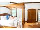A bedroom featuring a wooden canopy bed and armoire at 3704 Hesters Store Rd, Hurdle Mills, NC 27541