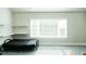 Bedroom featuring a full size bed, floating shelves, grey carpeting, and a large window at 3704 Hesters Store Rd, Hurdle Mills, NC 27541