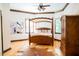 A bedroom featuring a wooden canopy bed, wooden floors, and an armoire at 3704 Hesters Store Rd, Hurdle Mills, NC 27541
