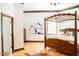 A bedroom featuring wood floors, a wooden canopy bed, and large windows at 3704 Hesters Store Rd, Hurdle Mills, NC 27541