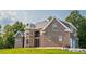 Handsome brick home with a stone facade, a metal roof, and multiple windows overlooks the lush, green lawn at 3704 Hesters Store Rd, Hurdle Mills, NC 27541