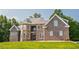 Lovely brick home featuring a stone facade, a metal roof, and multiple windows overlooking a manicured lawn at 3704 Hesters Store Rd, Hurdle Mills, NC 27541