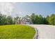 Two-story brick home with a long driveway, set amidst lush greenery and well-maintained landscaping at 3704 Hesters Store Rd, Hurdle Mills, NC 27541