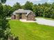 Brick home with spacious front lawn, complemented by mature trees and tasteful landscaping at 3704 Hesters Store Rd, Hurdle Mills, NC 27541