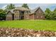 Two-story brick home with stone accents, bay windows, and manicured front lawn at 3704 Hesters Store Rd, Hurdle Mills, NC 27541