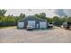 Large garage with ample parking and storage on a gravel lot, featuring a vehicle and equipment at 3704 Hesters Store Rd, Hurdle Mills, NC 27541