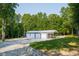 Detached garage with multiple bays, nestled in a serene setting with mature trees and a well-maintained lawn at 3704 Hesters Store Rd, Hurdle Mills, NC 27541