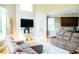 Bright living room with a large sectional couch, television, and view into the kitchen at 3704 Hesters Store Rd, Hurdle Mills, NC 27541