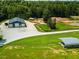 View of an outbuilding with two garage bays on a large property with a pond and additional storage at 3704 Hesters Store Rd, Hurdle Mills, NC 27541