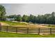 Picturesque country landscape with a pond, fenced pasture, and various outbuildings on the property at 3704 Hesters Store Rd, Hurdle Mills, NC 27541