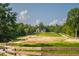 Beautiful country estate with a scenic pond, lush greenery, and a charming brick home in the background at 3704 Hesters Store Rd, Hurdle Mills, NC 27541