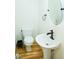 This powder room features a pedestal sink, oval mirror, and wood-look flooring at 3704 Hesters Store Rd, Hurdle Mills, NC 27541