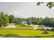 Expansive country estate featuring a scenic pond, lush greenery, and outbuildings at 3704 Hesters Store Rd, Hurdle Mills, NC 27541