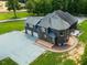 Rear aerial view of brick home featuring a patio, three-car garage, and circular driveway at 3704 Hesters Store Rd, Hurdle Mills, NC 27541