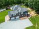 Aerial view showcasing a well-maintained brick home with an attached three-car garage at 3704 Hesters Store Rd, Hurdle Mills, NC 27541