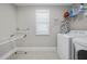 Bright laundry room featuring a washer, dryer, ironing board and wire shelving at 398 Carolina Ave, Raleigh, NC 27606