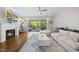 Cozy living room with fireplace, hardwood floors, ceiling fan, and a sliding glass door to the back porch at 398 Carolina Ave, Raleigh, NC 27606