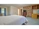 Bright bedroom with carpet, a brick accent wall, and access to an attached bathroom at 4005 King Charles Rd, Durham, NC 27707