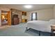 Spacious bedroom with a brick accent wall, built-in shelving, and plush carpeting at 4005 King Charles Rd, Durham, NC 27707